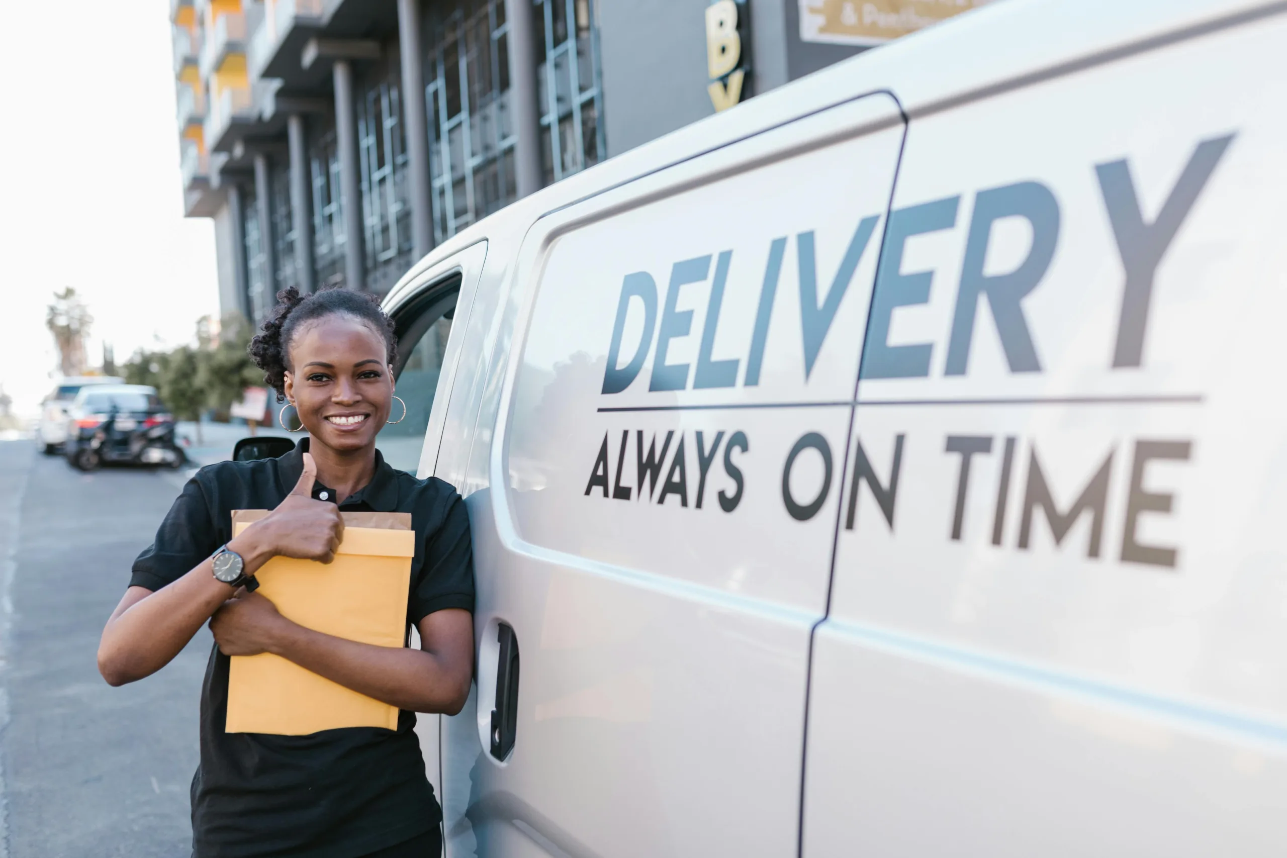 Girl giving a thumbs up by a van 